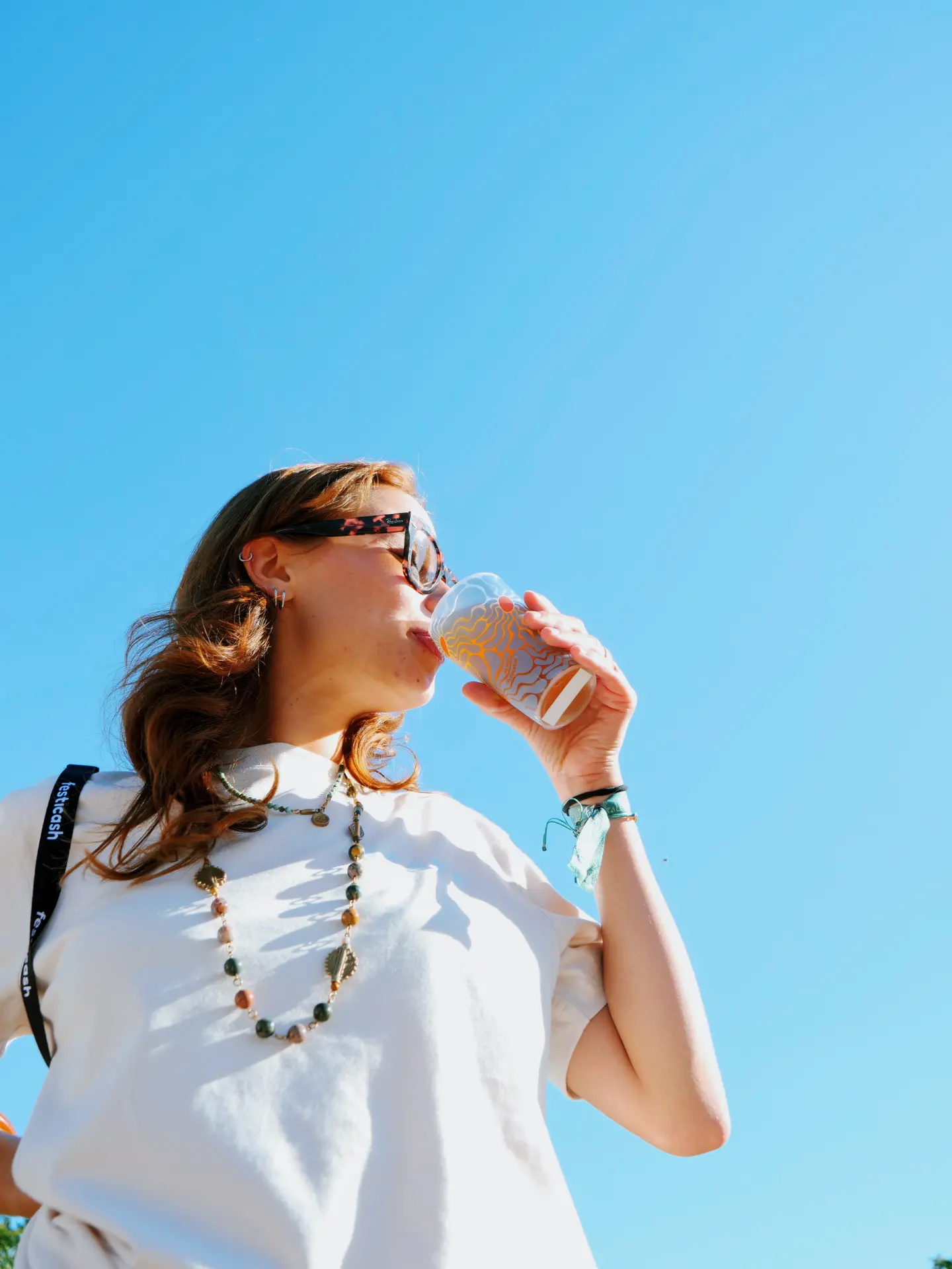 Festivalier profitant de sa boisson au milieu de la foule.