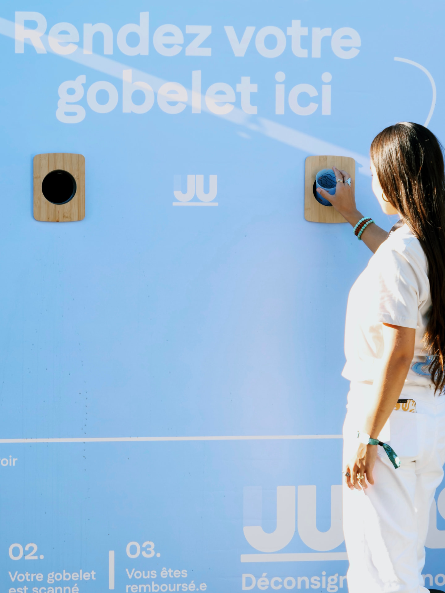 Dépôt d'un gobelet dans un bac de retour JUMS.